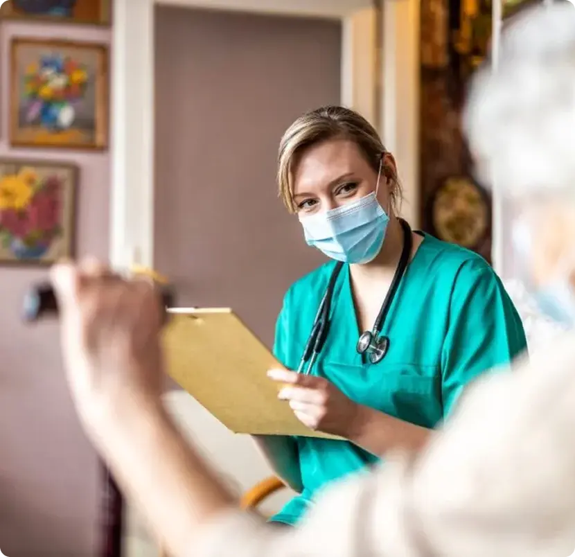 A woman discusses her medication with a nurse while holding a pill bottle in a healthcare setting.