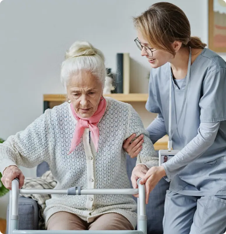 A nurse assists an elderly woman in a wheelchair