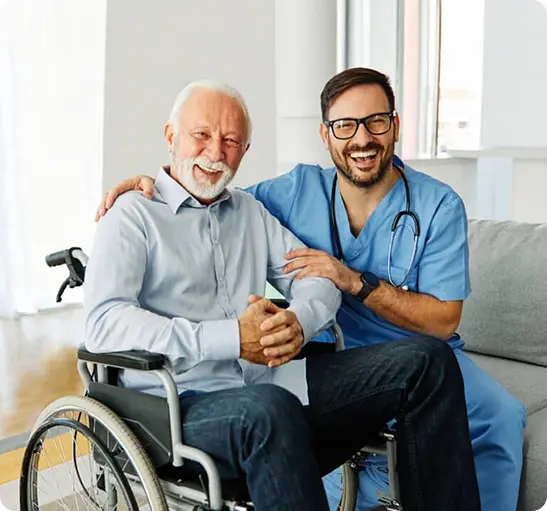 A man in a wheelchair sits beside a smiling man