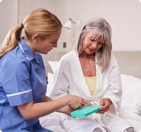 A nurse assists an older woman in using a tablet