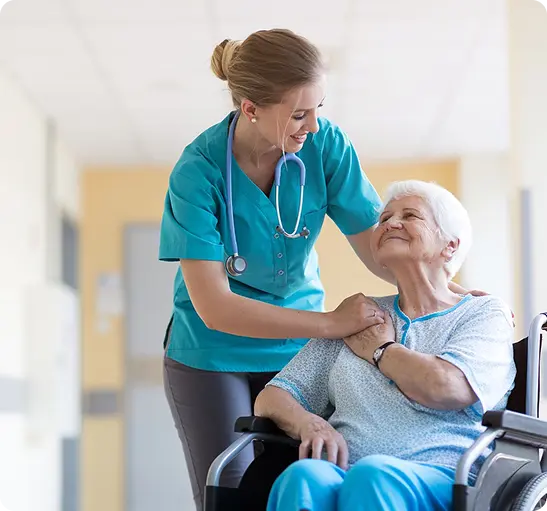 A nurse assists an elderly woman in a wheelchair