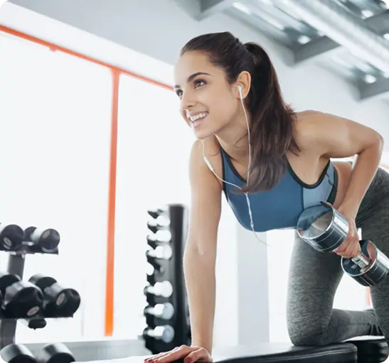 A woman is lifting weights in a gym