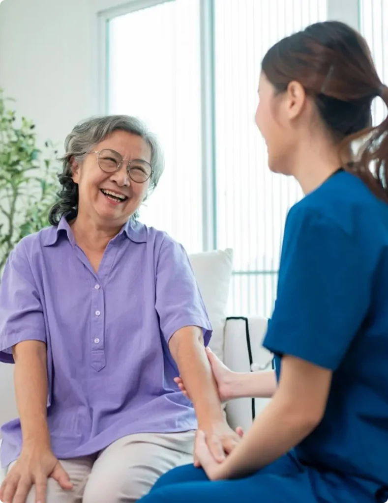 A woman wearing a blue shirt speaks with an older woman